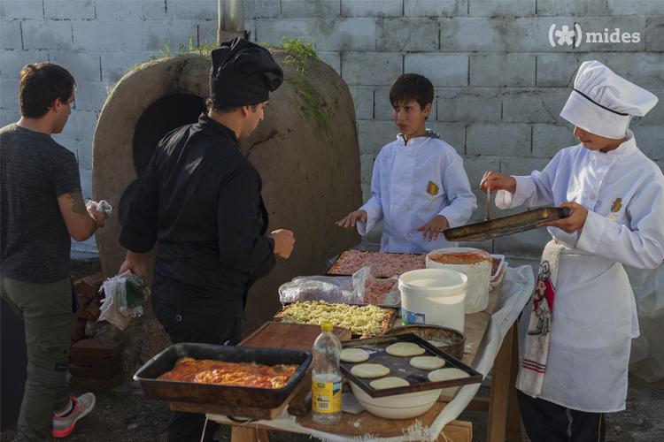 Estudiantes cocinando cerca del horno de barro