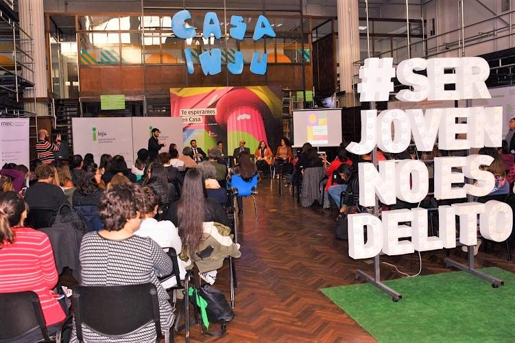 Vista del auditorio desde atrás y sobre el fondo, la mesa de debate