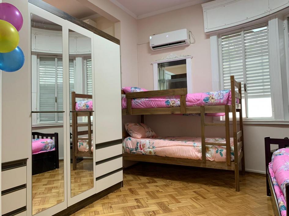 Dormitorio, ropero blanco grande con puerta de espejos, cuchetas y cama marinera con acolchados rosa