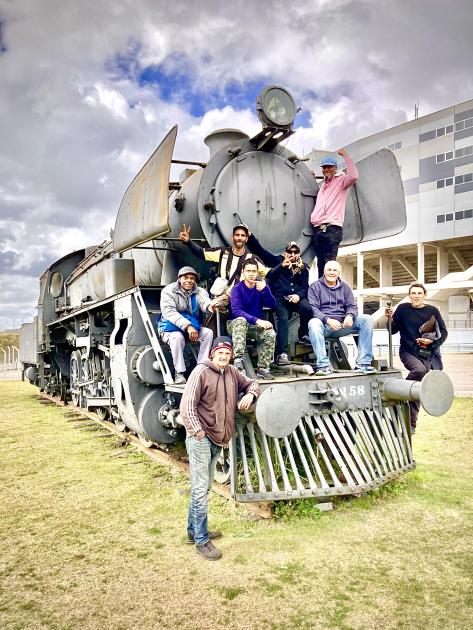 Participantes de programa MIDES posando junto a la locomotora símbolo del club carbonero