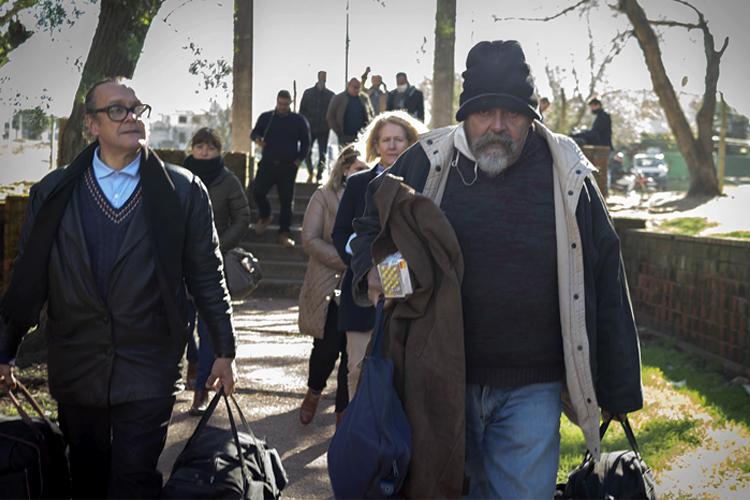 Juan y Alberto con sus bolsos caminando