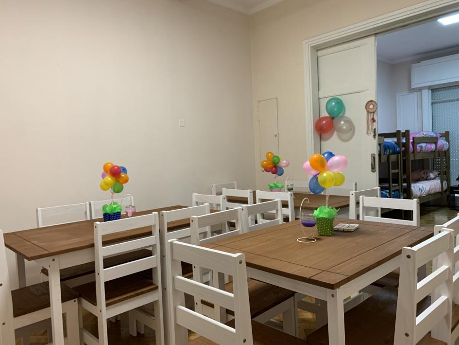 Comedor, mesas y sillas de madera rústica pintadas de blanco, centros de mesa con globos de colores