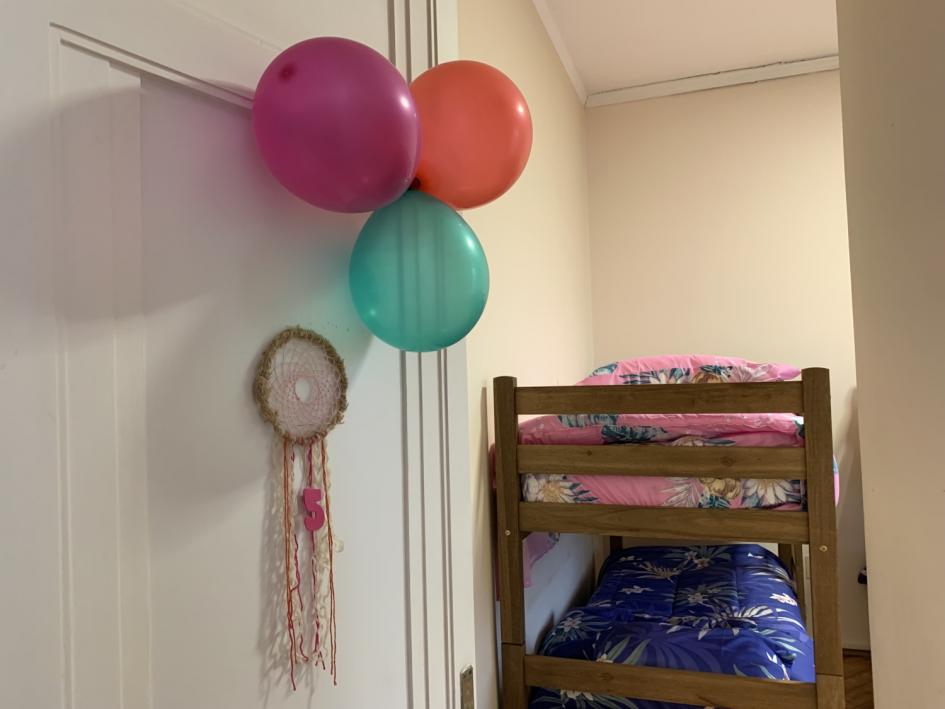 Dormitorio número 5, puerta decorada con globos y un atrapasueños, cuchetas 