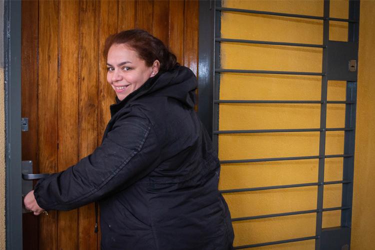 Paola ingresando a su casa Paola abriendo la puerta de su hogar