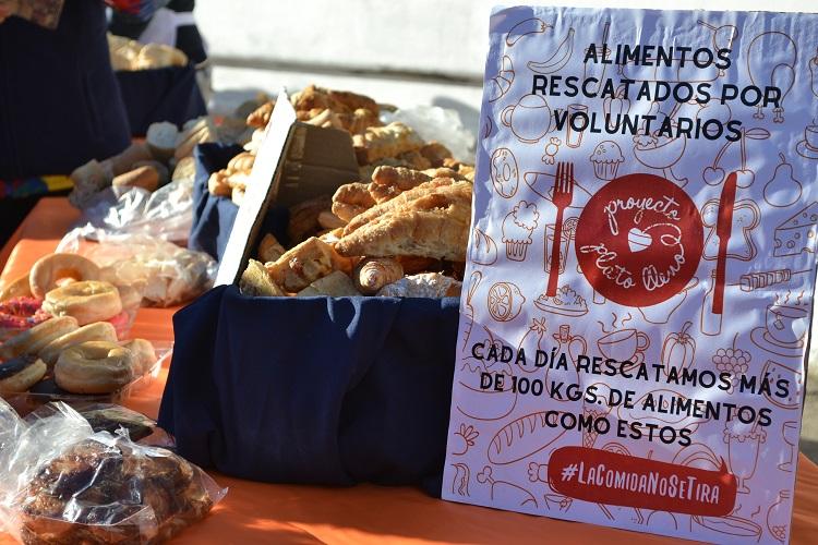 Bandeja con bizcochos y al lado un cartel que dice "alimentos rescatados por voluntarios, proyecto plato lleno".