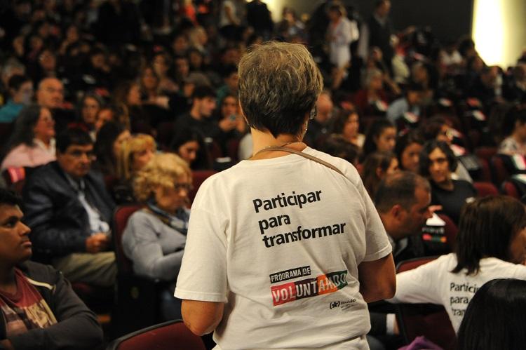 Mujer de espaldas con camiseta del programa donde se lee: "Participar para transformar".