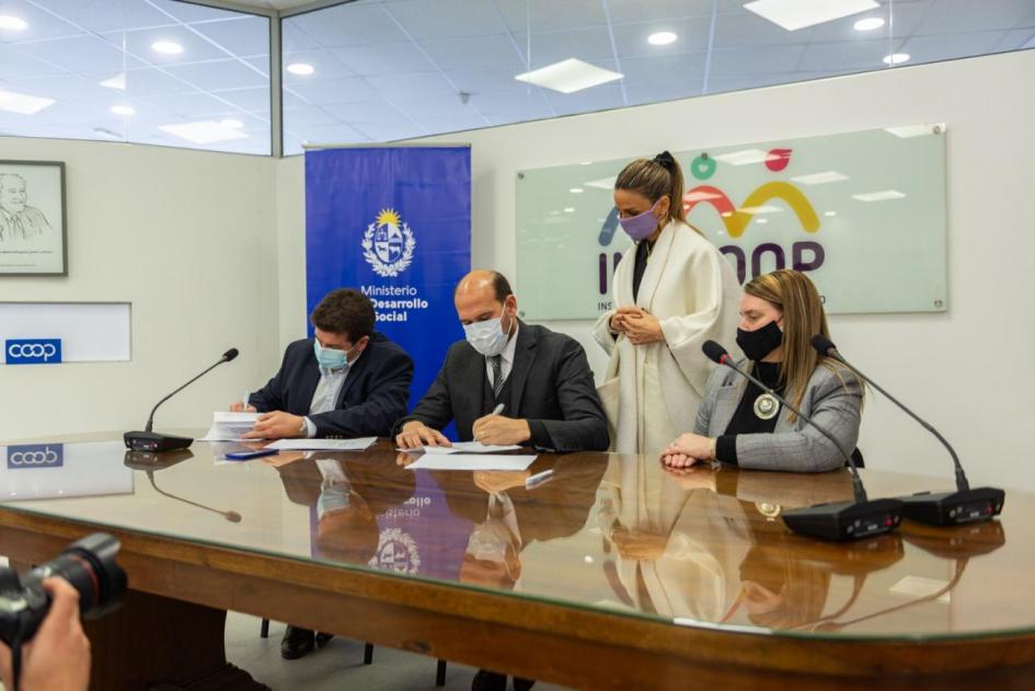 Autoridades en firma del convenio Martín Lema, Andrea Brugman y Martín Fernández en la mesa de firma del convenio