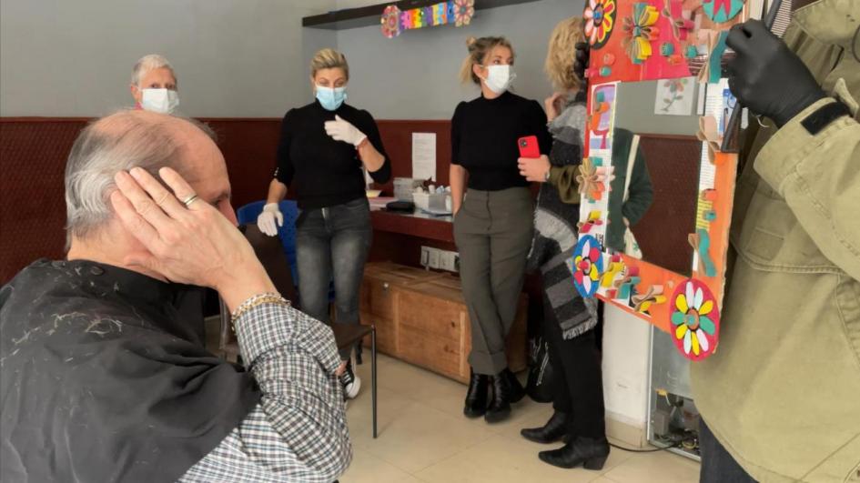 Primera jornada solidaria de peluquería en Montevideo Hombre se mira al espejo luego de corte de cabello realizado en jornada solidaria