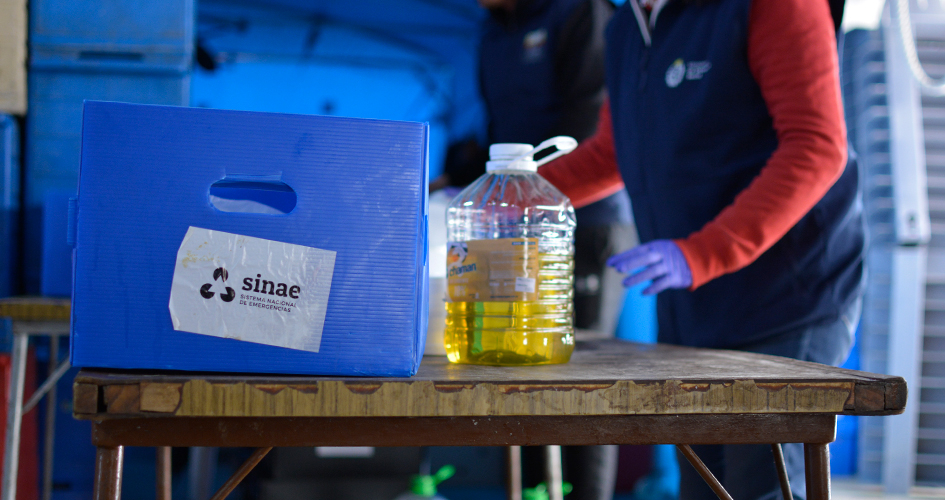 Caja azul con etiqueta de Sinae y bidón de detergente