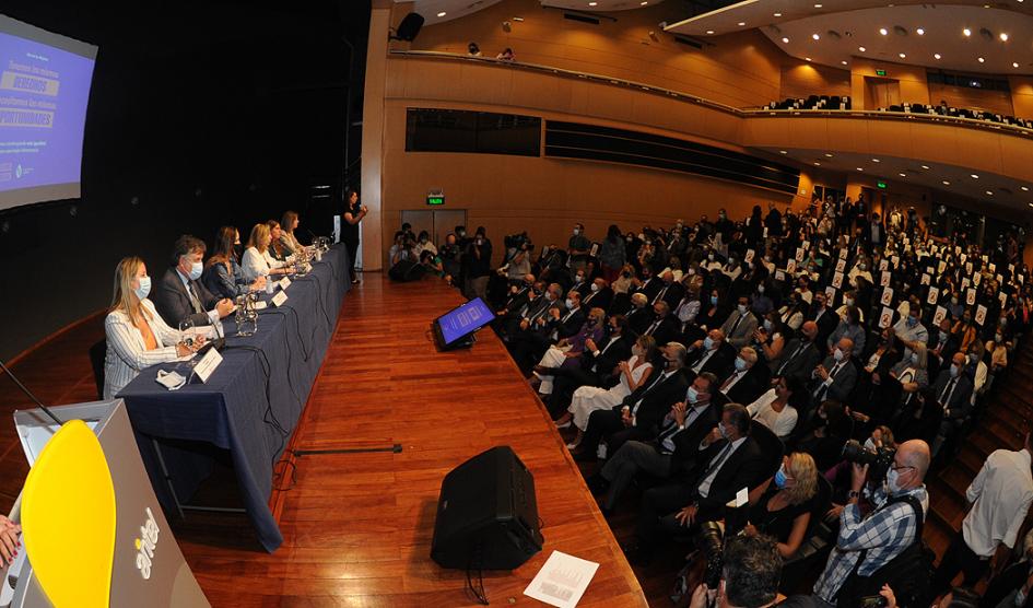 Foto lateral de la mesa de autoridades y público del evento