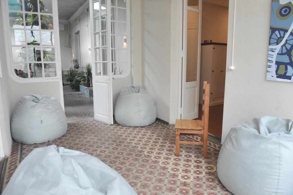 Espacio de descanso y esparcimiento. Habitación con cuatro puff blancos dispuestos a modo de living.