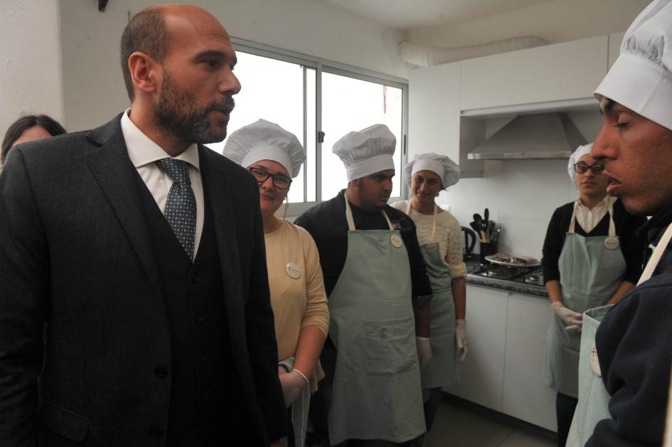 Ministro junto al personal de cocina del establecimiento Margaritas II. Ministro Lema junto a varias personas con indumentaria de chef en la cocina del alojamiento.