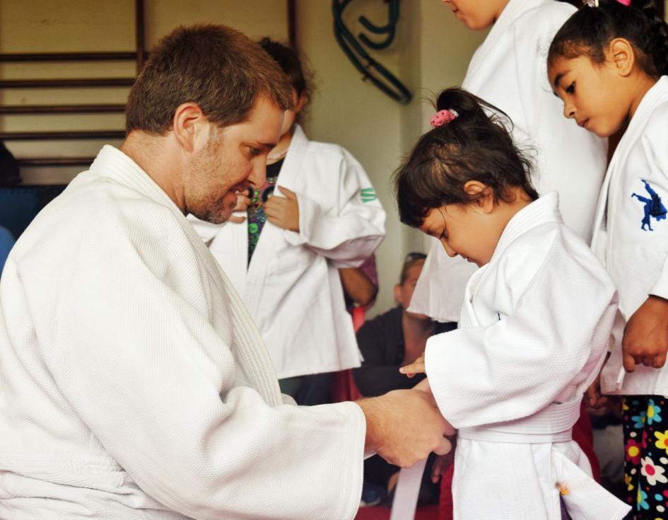 Profe de Judo ayudando a una alumna 