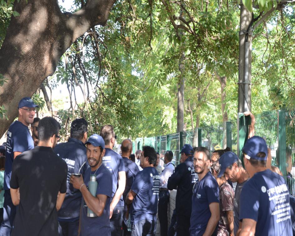Trabajadores de la coopeativa COOMI bajo el árbol principal del Cachón esperan a las autoridades