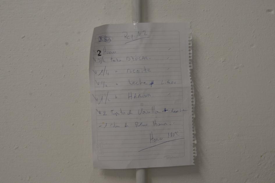 Hoja de cuaderno pegada en la pared con receta escrita a mano.