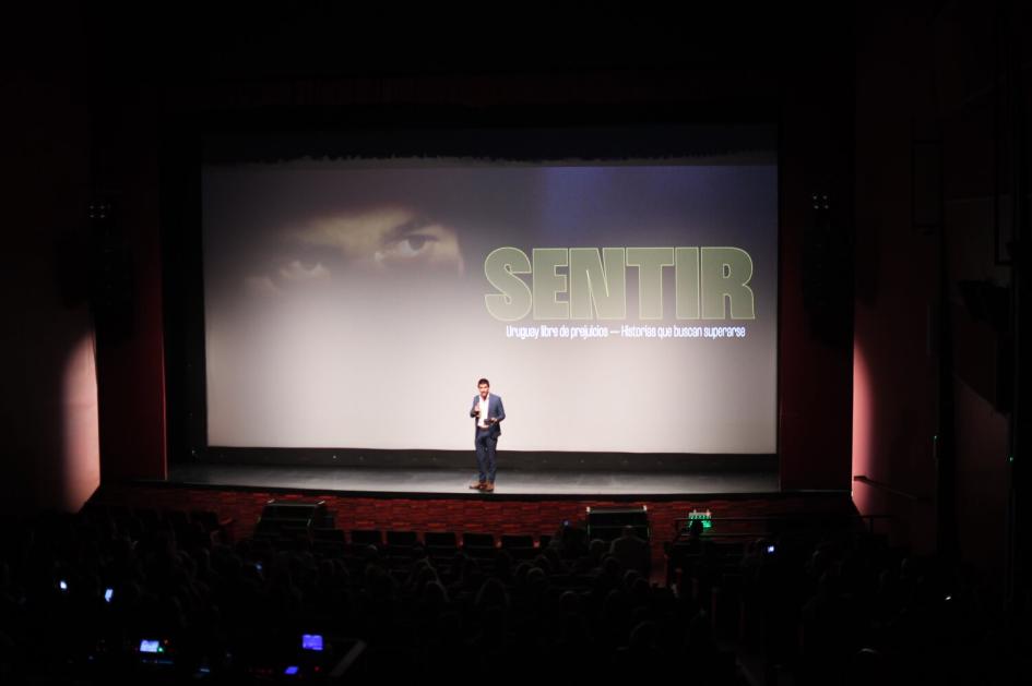 Ministro de Mides, en el discurso de la proyección del documental Ministro de MIDES, en escenario dando discurso sobre el documental