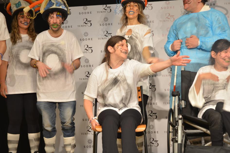 Murga La de ACRIDU presentando “El Mundo de Valeria”. Murga integrada por grupo de jóvenes con discapacidad, algunos de pie, otros en silla de ruedas.