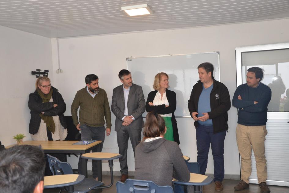 Autoridades de Mides, Dinali e Inefop junto a docentes de Adra. 6 personas de pie frente a un grupo de alumnos que asisten a primer día de clases