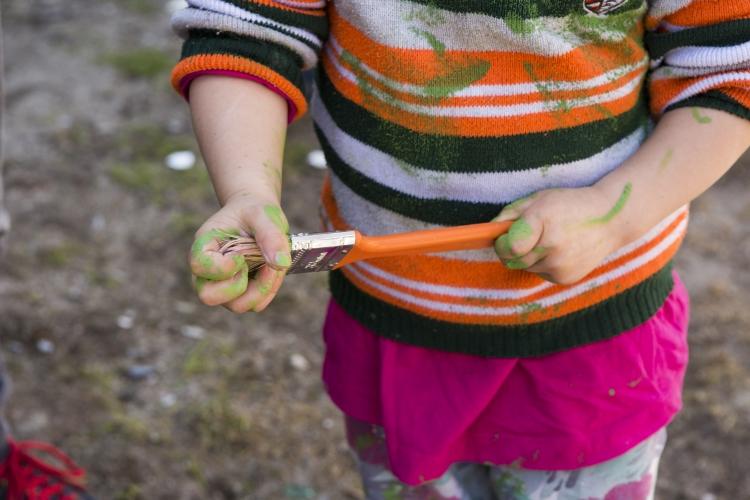 Niña pintando con un pincel Niña pintando con un pincel