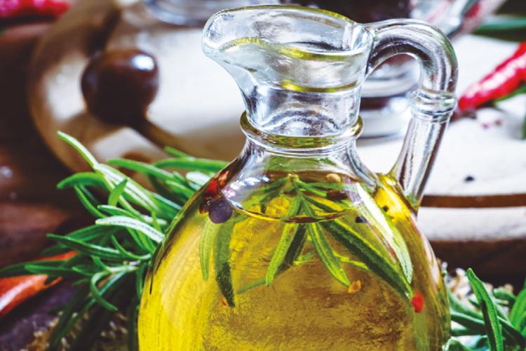 Aceitera repleta de aceite con vegetales dentro