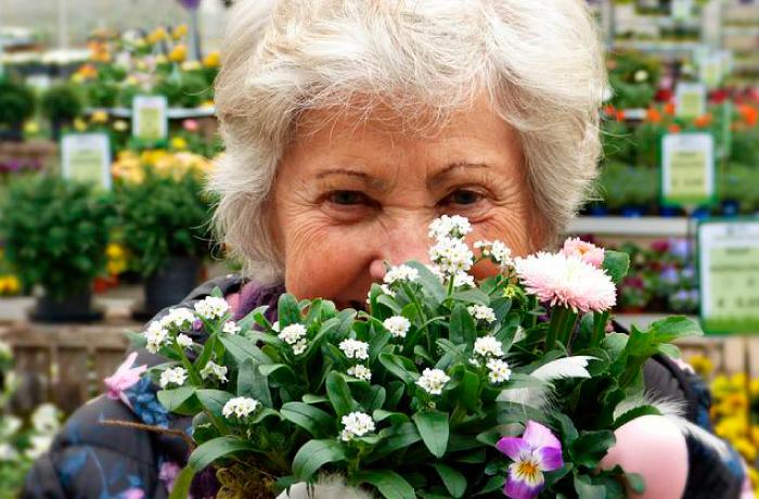 Mujer mayor sostiene flor