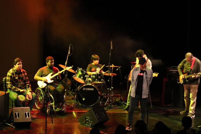 Grupo de hombres ciegos tocan instrumentos musicales en escenario de sala Hugo Balzo.o 