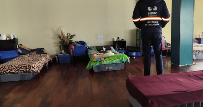 camas tendidas dispuestas en el suelo y un funcionario de Sinae de espaldas