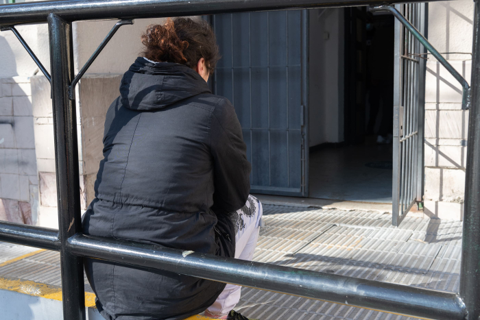 Persona esperando en la puerta de un centro de evacuados