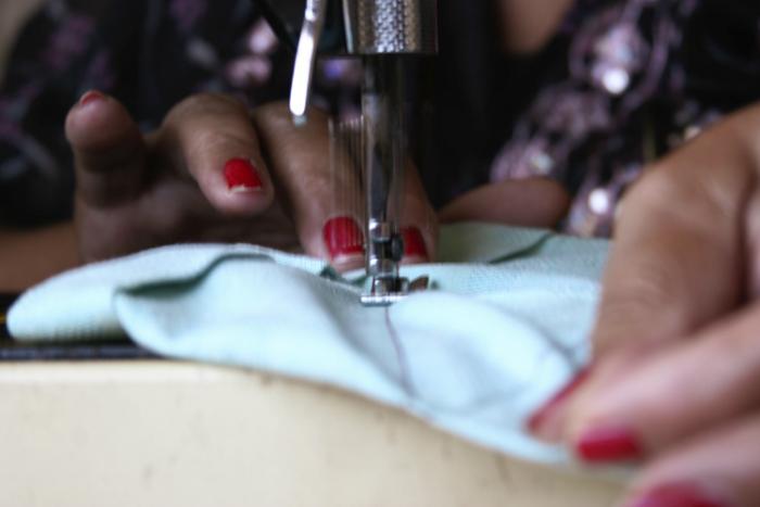 Manos de mujer trabajando con una máquina de coser