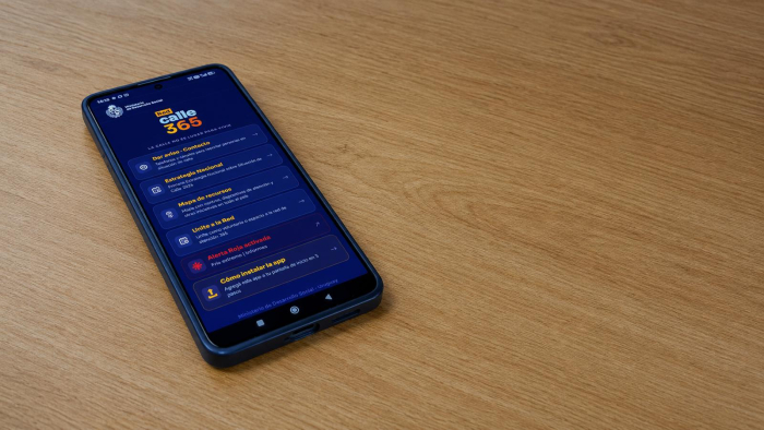 Nueva aplicación Red 365 del Ministerio de Desarrollo Social. Un celular sobre una mesa muestra la aplicación abierta.
