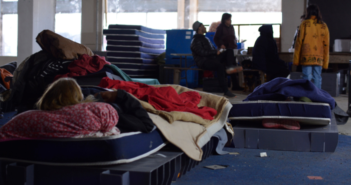 Personas durmiendo en colchones en el ex Aeropuerto de Carrasco