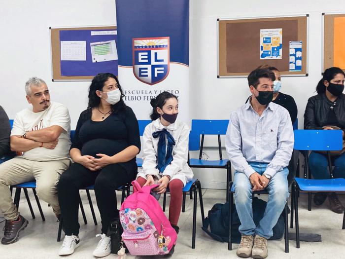 Gente sentada en una silla mirando hacia la derecha