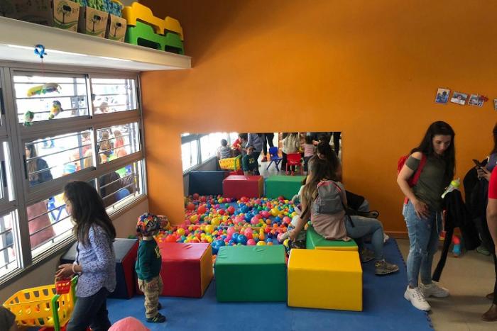 Momento de una actividad durante la inauguración de un Centro CAIF, en la que se ven niños y madres en un pelotero