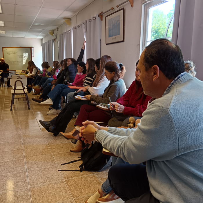 Un grupo de personas sentadas en ronda intercambian sobre las bases del plan.