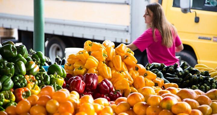 Mujer comprando en local de frutas y verduras