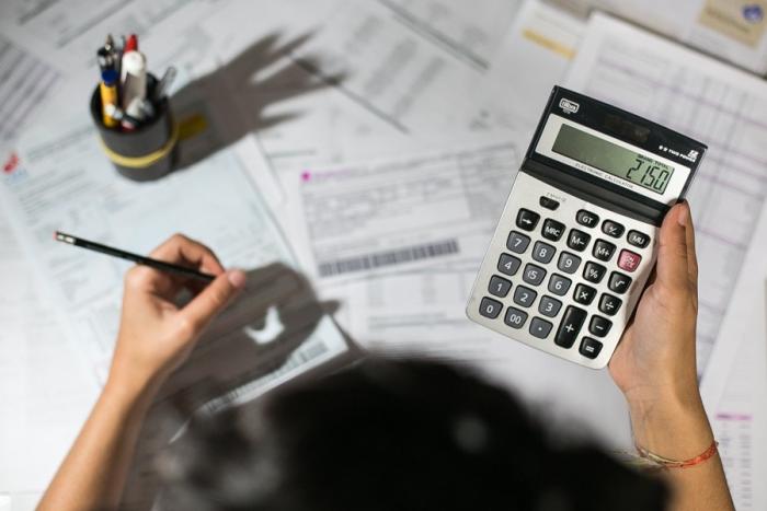 Persona haciendo cálculos con una calculadora