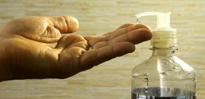 Tabla comparativa de precios de productos de cuidado personal Mano poniéndose alcohol en gel