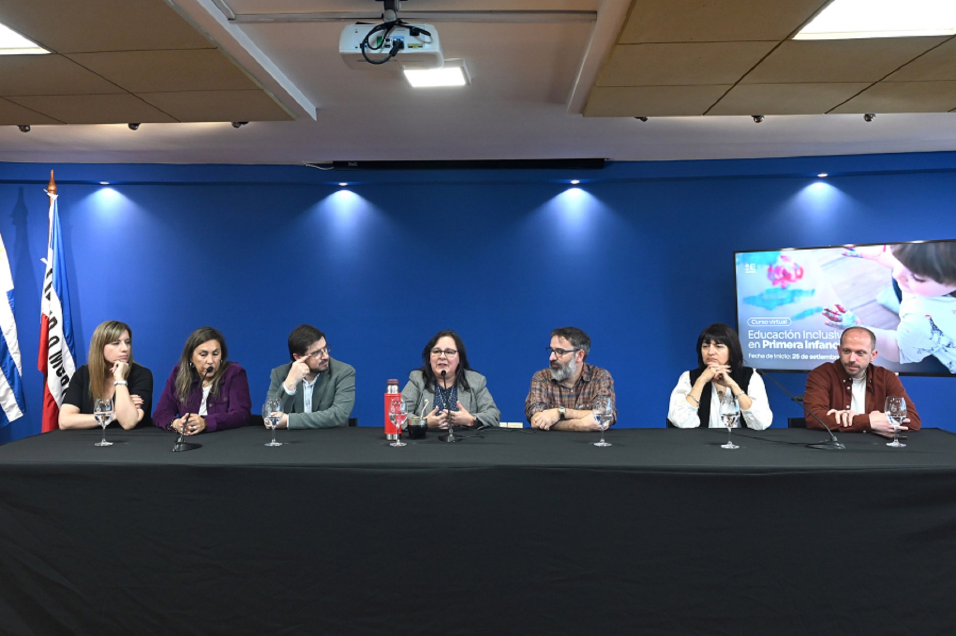 Personas en mesa hablando al público.