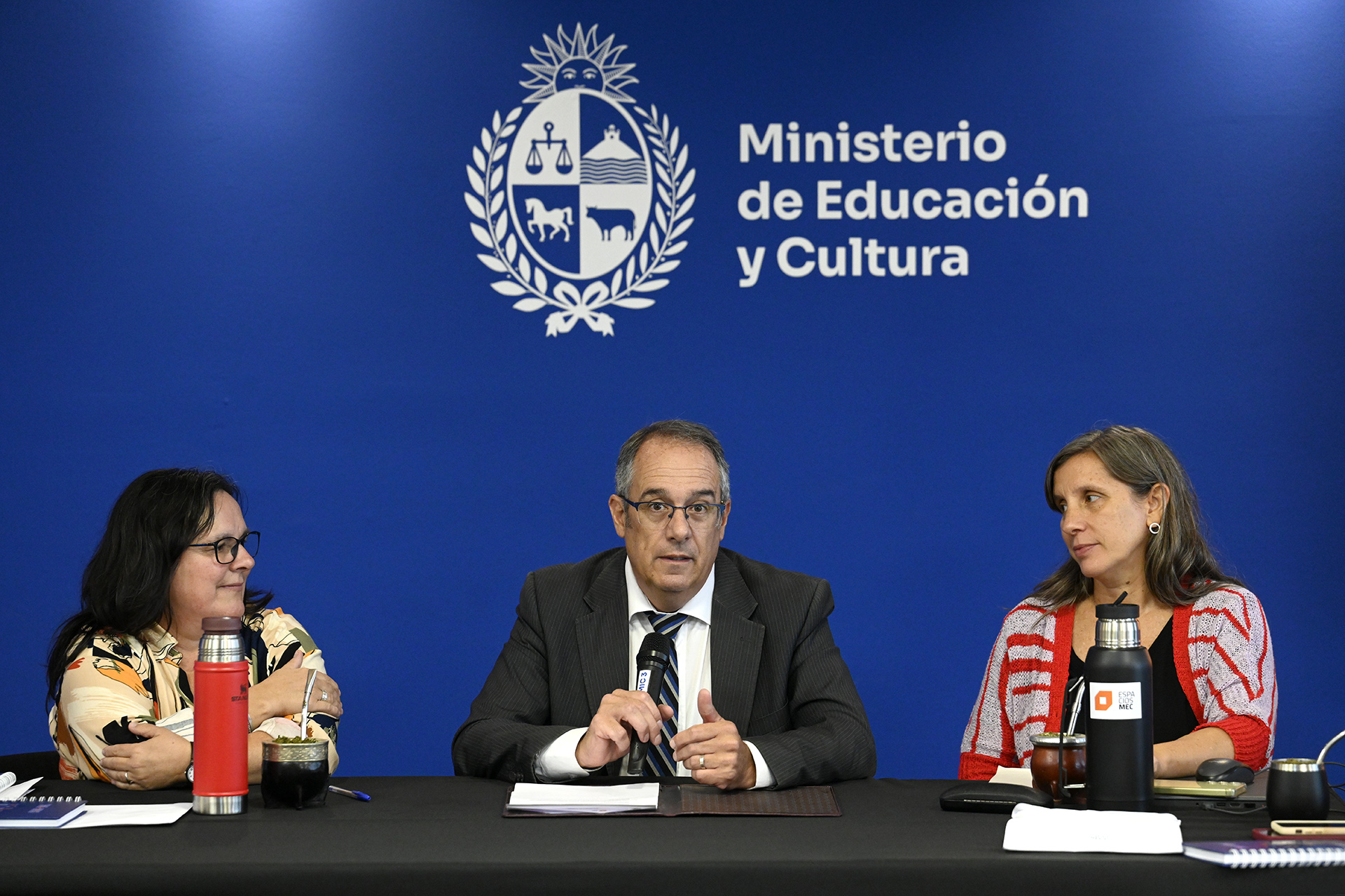 Personas en mesa hablando al público.