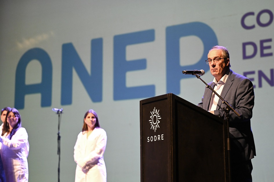 Ministro hablando al público desde un atril.