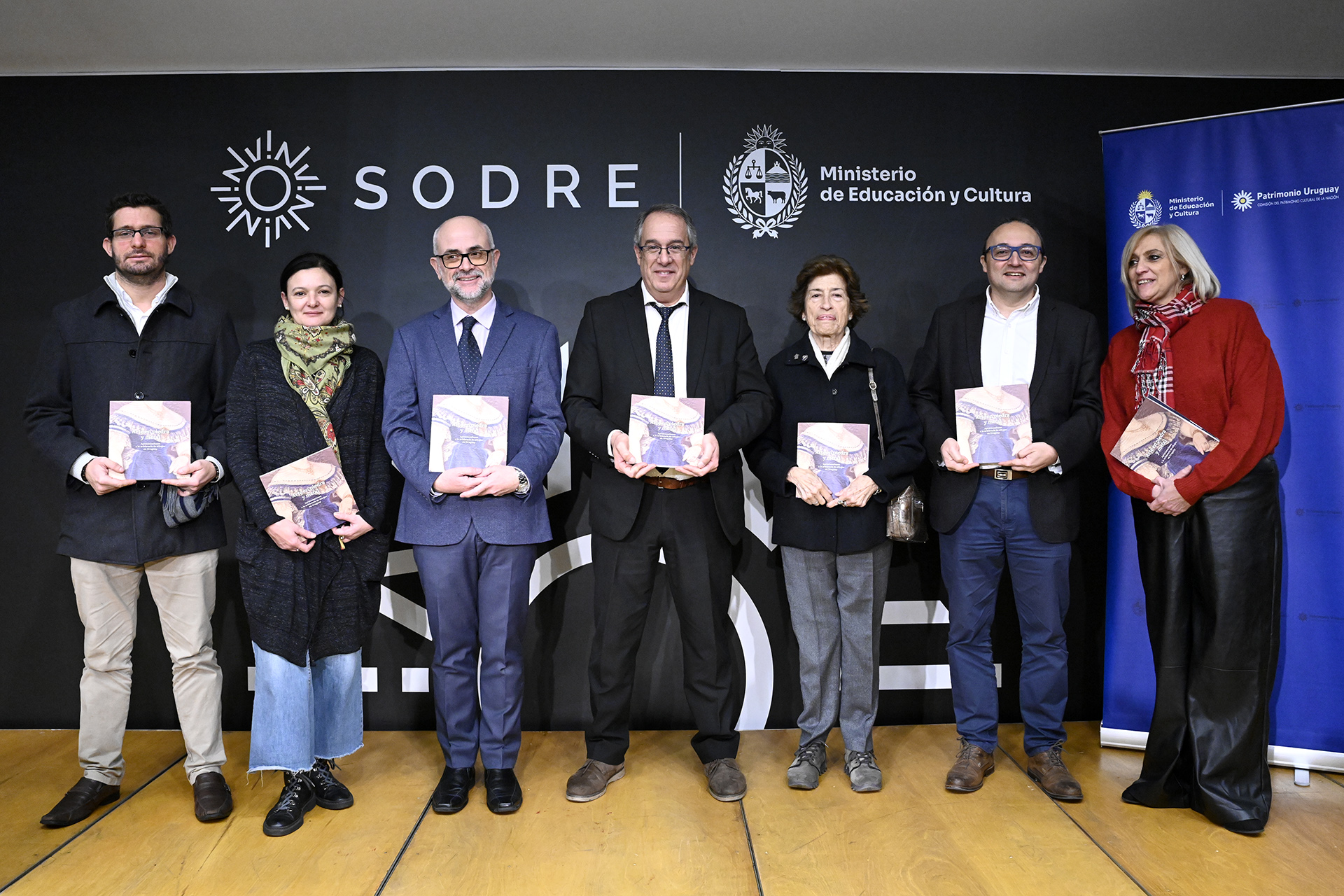 Autoridades posan para foto con libro 