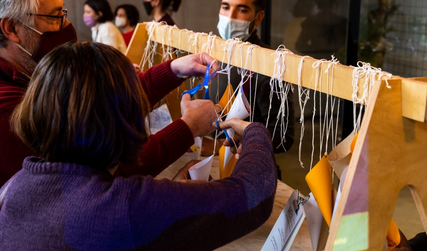 Personas cortando con tijera las piolas que enganchan a los conitos de comida