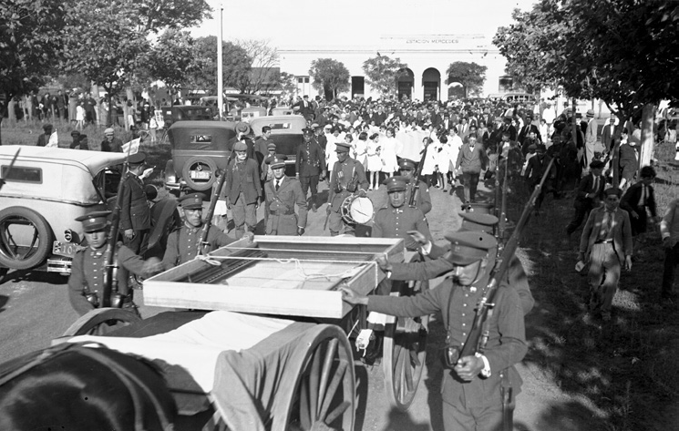 Al arribo del tren de la “Cruzada Cultural” a la ciudad de Mercedes, una bandera utilizada en 1825, enmarcada y dispuesta en una caja con cubierta de vidrio, y montada sobre una cureña, encabezó una manifestación patriótica por las calles de la ciudad (1934). Archivo de la Imagen y la Palabra, SODRE.