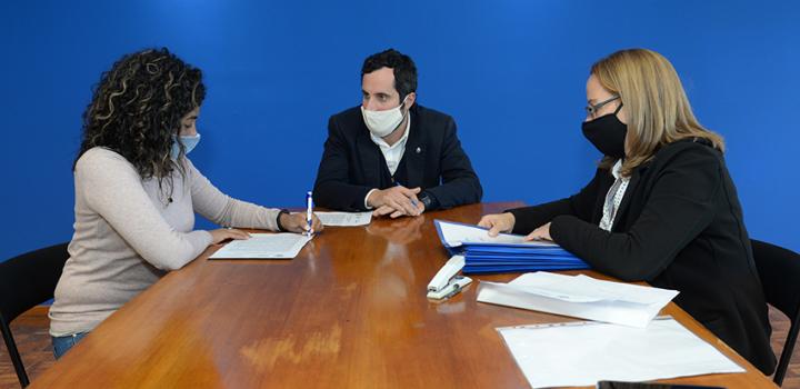 Persona beneficiaria de la beca, Director de Educación y encargada de la Oficina de becas firmando