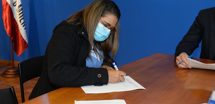 Persona beneficiaria de la beca firmando contrato