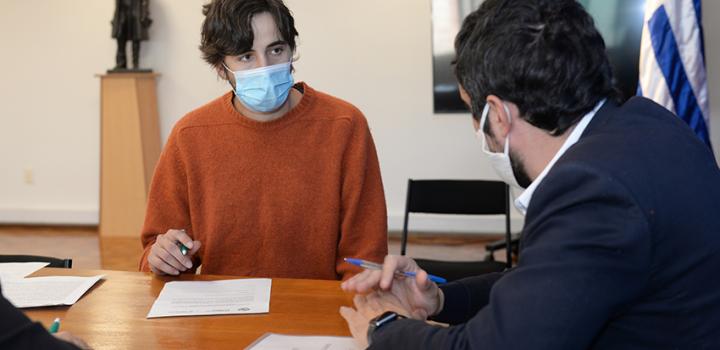 Persona beneficiaria de la beca, Director de Educación firmando contrato