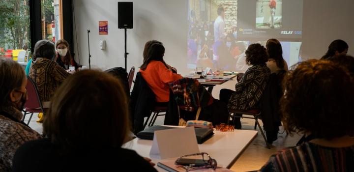 Participantes mirando la pantalla donde un proyector está pasando imágenes