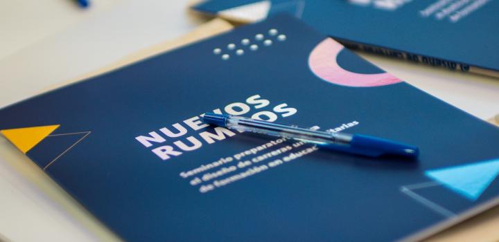 Carpetas con el diseño de Nuevos Rumbos y una lapicera arriba
