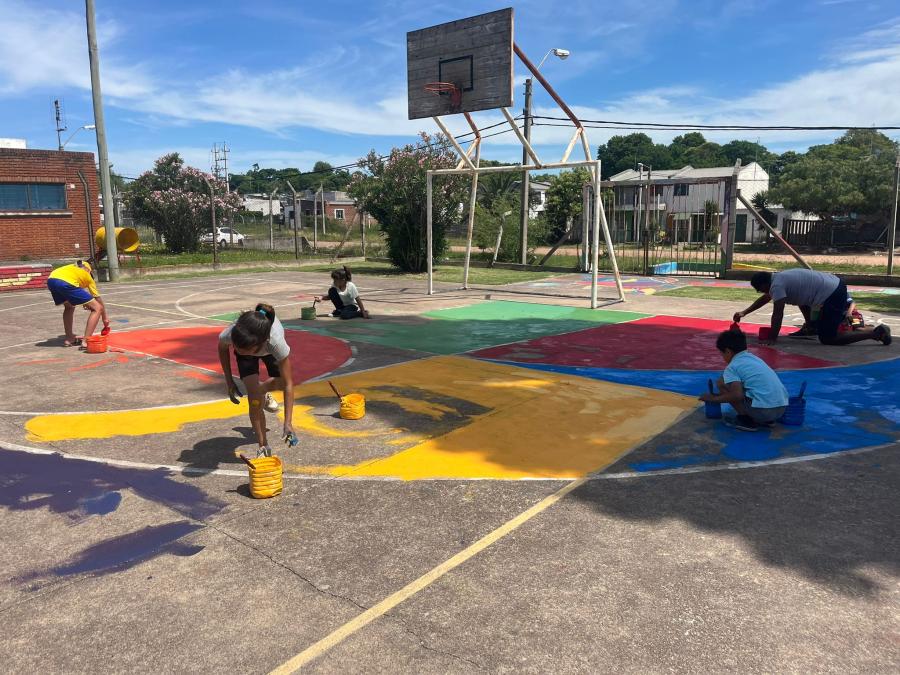 personas pintando cancha deportiva