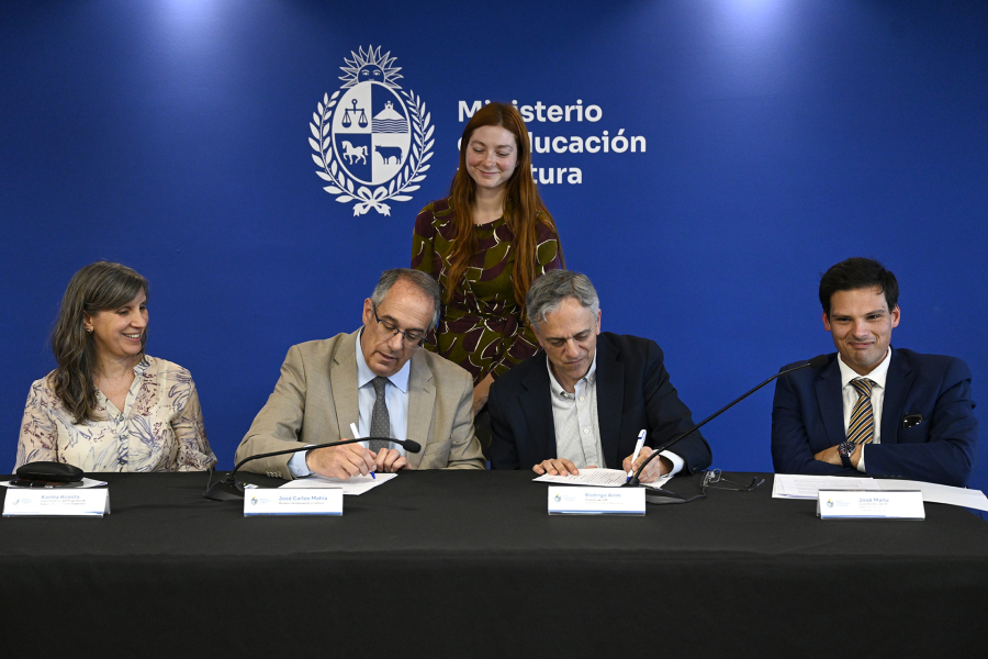 Personas firmando un documento.